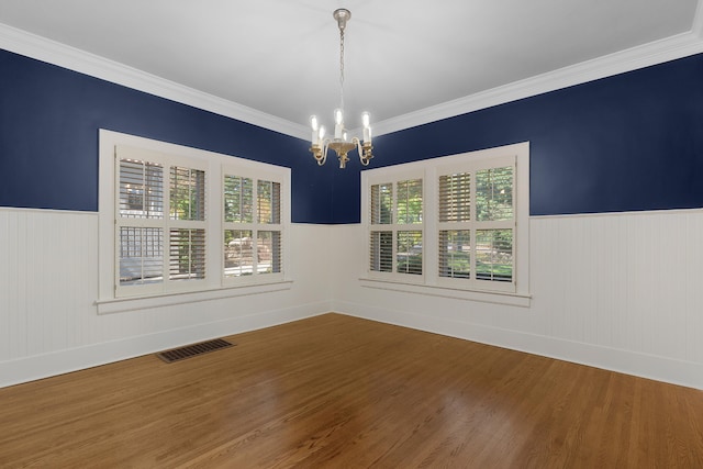 unfurnished room with a wealth of natural light, crown molding, and wood-type flooring