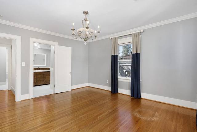 unfurnished room featuring a notable chandelier, hardwood / wood-style flooring, ornamental molding, and sink