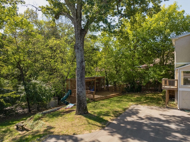 view of yard featuring a playground and a wooden deck