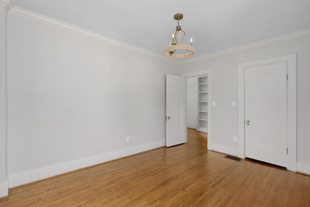 empty room featuring ornamental molding and light hardwood / wood-style floors