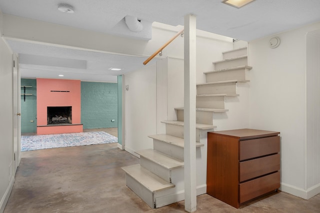 stairway featuring concrete floors and a textured ceiling