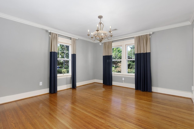 unfurnished room with a notable chandelier, ornamental molding, wood-type flooring, and plenty of natural light