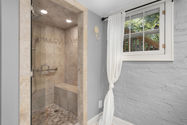 bathroom with brick wall and an enclosed shower