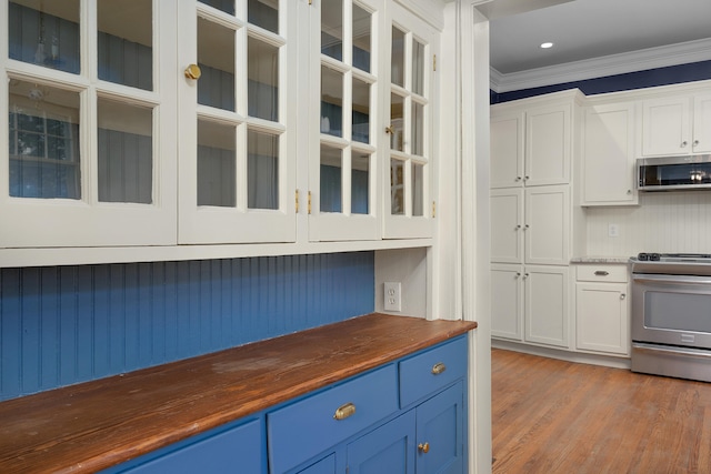 kitchen with hardwood / wood-style flooring, appliances with stainless steel finishes, blue cabinets, and white cabinets