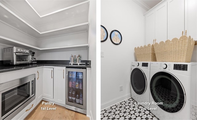 laundry room with cabinets, washing machine and dryer, wine cooler, and ornamental molding