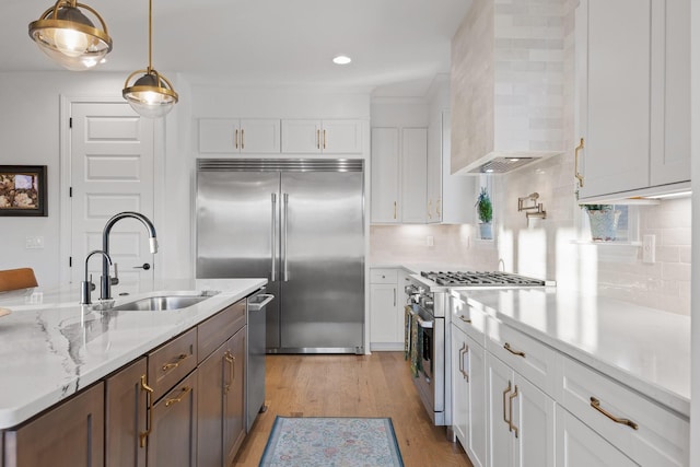 1871 Notting Hl, Chattanooga, TN 37405 - kitchen featuring wall chimney exhaust hood, white cabinetry, premium appliances, and a sink