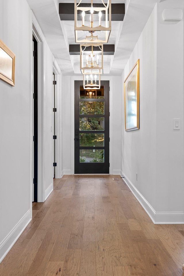 entrance foyer with wood-type flooring and an inviting chandelier