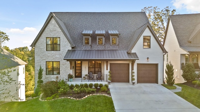 view of front of property with covered porch, a front yard, and a garage