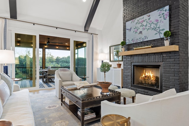 living room featuring vaulted ceiling with beams, wood-type flooring, and a brick fireplace