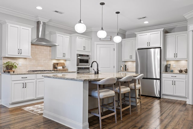 kitchen featuring wall chimney exhaust hood, appliances with stainless steel finishes, and white cabinets