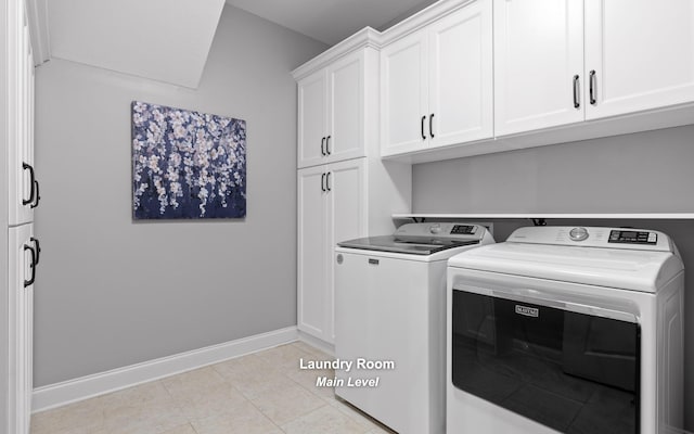 washroom featuring independent washer and dryer, light tile patterned floors, and cabinets