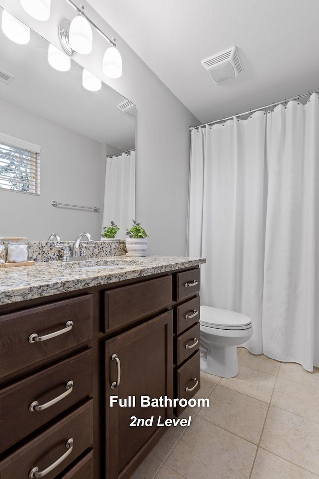 bathroom with vanity, toilet, and tile patterned flooring