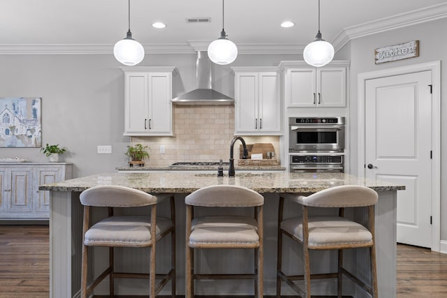 kitchen featuring a kitchen island with sink, wall chimney exhaust hood, dark hardwood / wood-style floors, and white cabinets