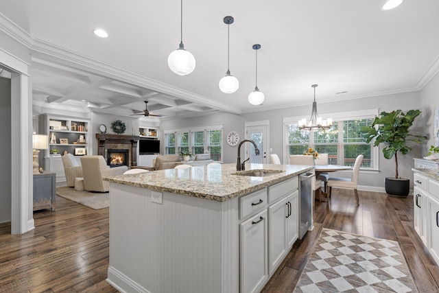 kitchen with dark wood-type flooring, coffered ceiling, sink, and decorative light fixtures