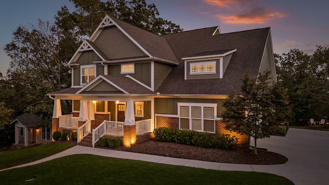 craftsman house with covered porch and a lawn