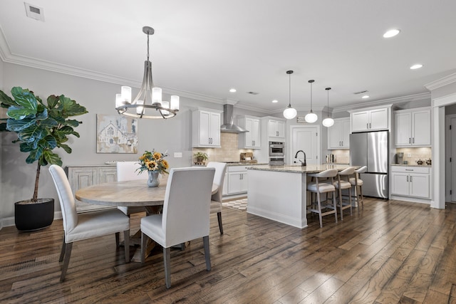 dining area with ornamental molding, dark wood-type flooring, and a chandelier