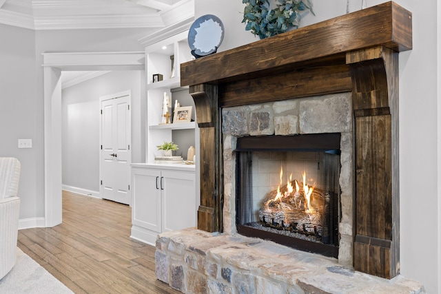 details featuring ornamental molding, a fireplace, and hardwood / wood-style floors