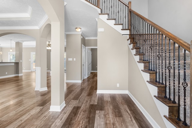 interior space with crown molding, a textured ceiling, hardwood / wood-style flooring, and a chandelier