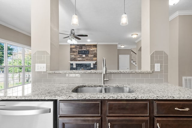 kitchen featuring tasteful backsplash, light stone countertops, sink, and decorative light fixtures