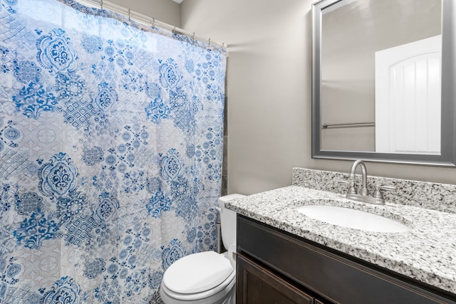 bathroom with vanity, toilet, and walk in shower