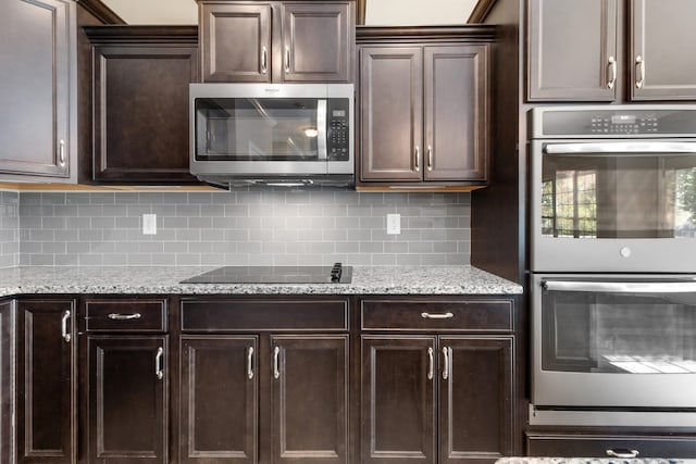 kitchen featuring appliances with stainless steel finishes, decorative backsplash, light stone counters, and dark brown cabinets