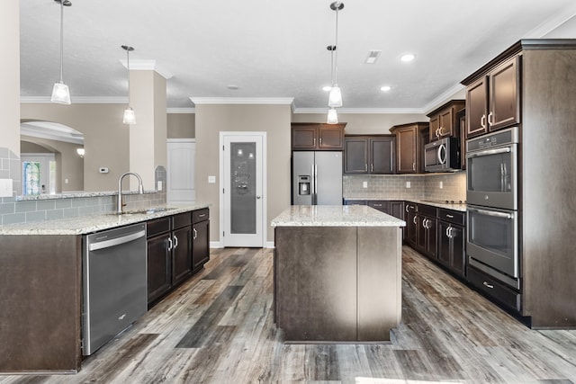 kitchen featuring sink, appliances with stainless steel finishes, decorative light fixtures, and dark hardwood / wood-style floors