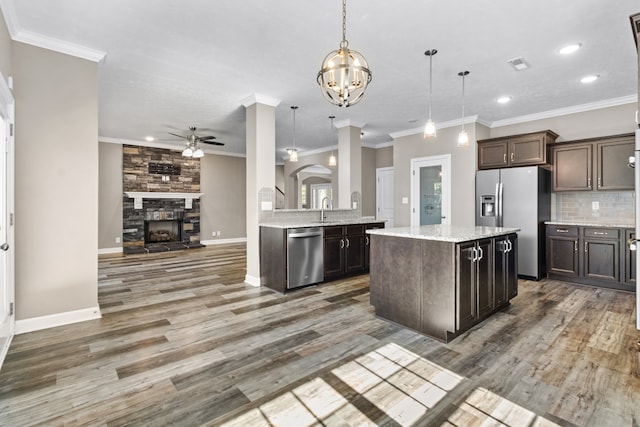 kitchen with appliances with stainless steel finishes, dark brown cabinetry, pendant lighting, and dark hardwood / wood-style floors