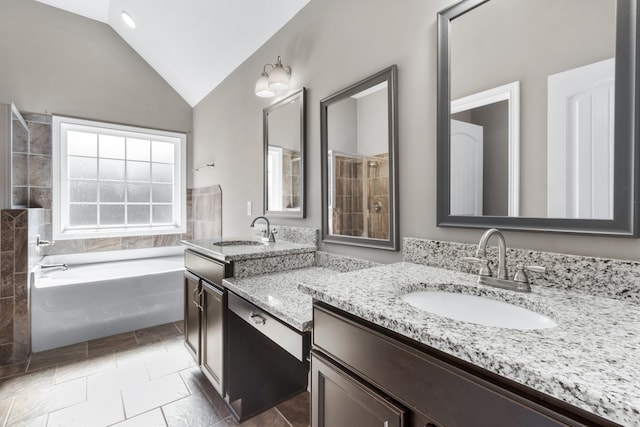 bathroom featuring vanity, a tub, vaulted ceiling, and tile patterned flooring