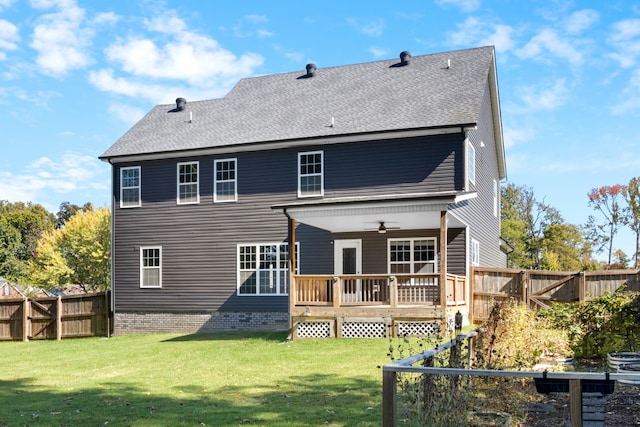 rear view of property featuring ceiling fan, a deck, and a lawn