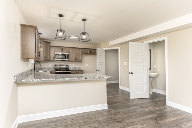 kitchen featuring kitchen peninsula, dark hardwood / wood-style flooring, light stone countertops, pendant lighting, and stainless steel appliances