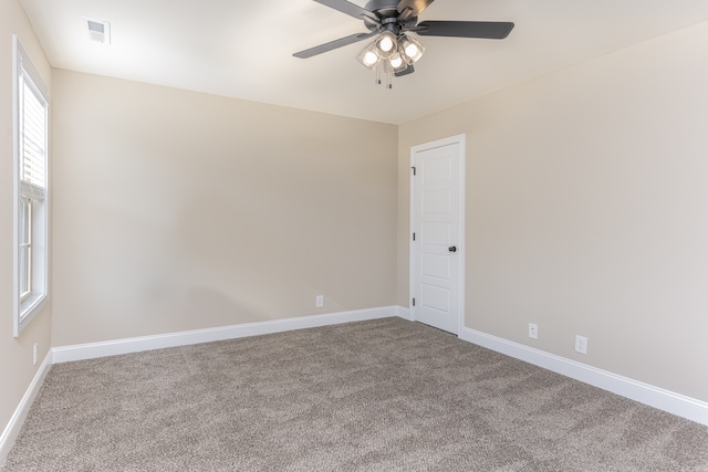 empty room with ceiling fan and light colored carpet