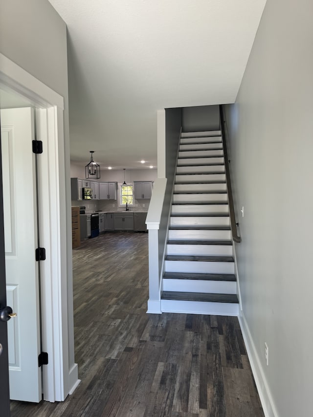 stairs featuring sink and wood-type flooring