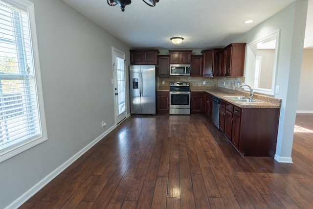 kitchen with sink, appliances with stainless steel finishes, tasteful backsplash, and dark hardwood / wood-style flooring