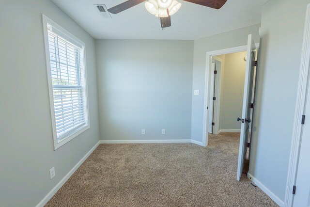 empty room with light colored carpet and ceiling fan