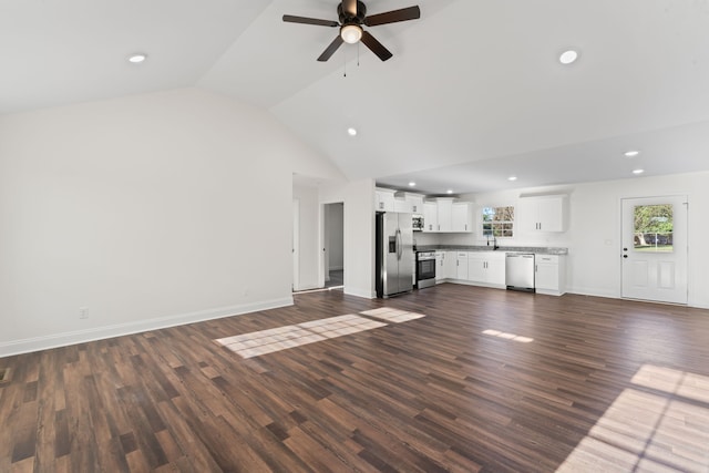 unfurnished living room with dark hardwood / wood-style floors, ceiling fan, sink, and vaulted ceiling