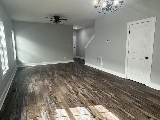 interior space featuring dark wood-type flooring and ceiling fan with notable chandelier