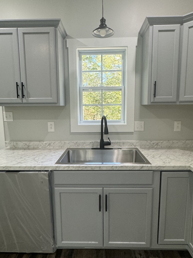 kitchen featuring pendant lighting, sink, and gray cabinetry