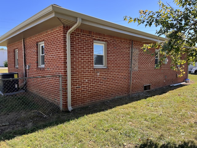 view of side of home featuring a lawn and central AC unit