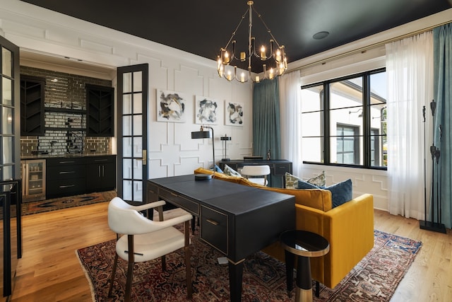 dining space with wine cooler, light hardwood / wood-style flooring, and a notable chandelier