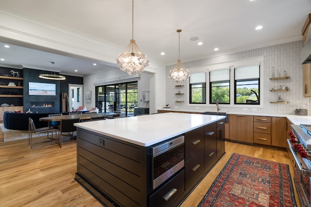 kitchen featuring decorative backsplash, a center island, light wood-type flooring, and plenty of natural light