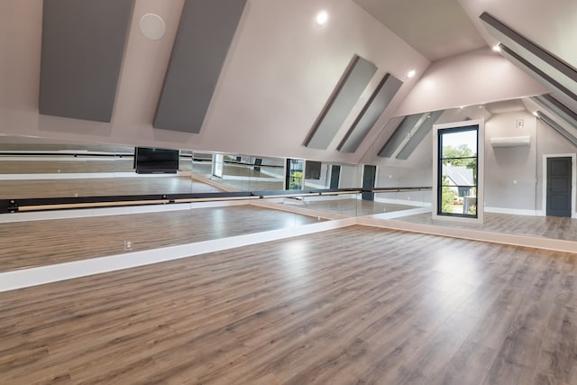 workout area featuring hardwood / wood-style flooring and high vaulted ceiling