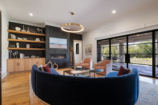 living room featuring a large fireplace, ornamental molding, and light hardwood / wood-style floors