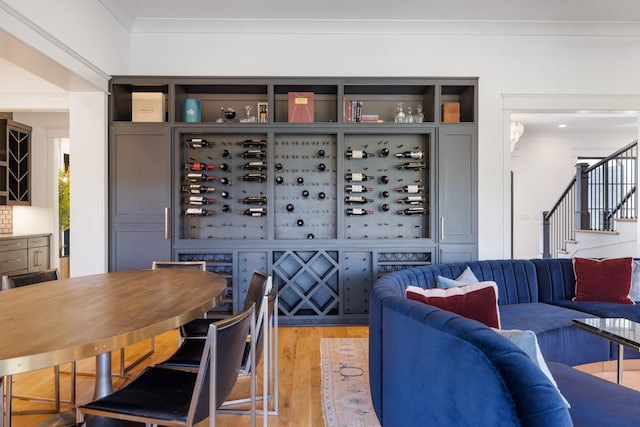 wine area with crown molding and light wood-type flooring