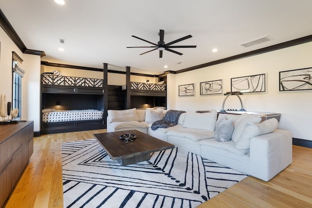 living room with crown molding, light hardwood / wood-style floors, and ceiling fan