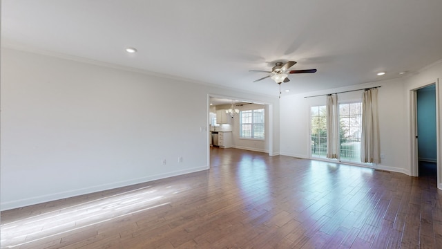 empty room with ornamental molding, hardwood / wood-style flooring, and ceiling fan with notable chandelier