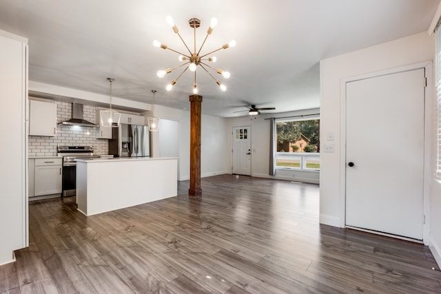 kitchen with wall chimney exhaust hood, dark wood-type flooring, stainless steel appliances, a center island, and pendant lighting