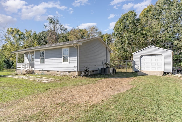 view of front of home featuring central air condition unit, a front yard, a garage, and an outdoor structure