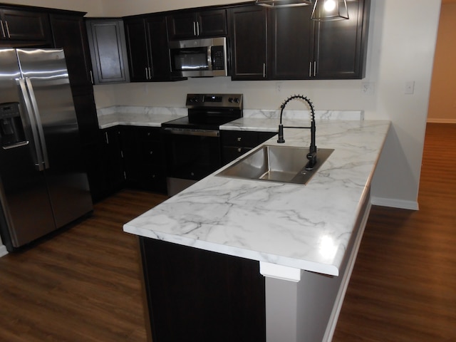 kitchen featuring light stone countertops, appliances with stainless steel finishes, dark hardwood / wood-style flooring, and sink