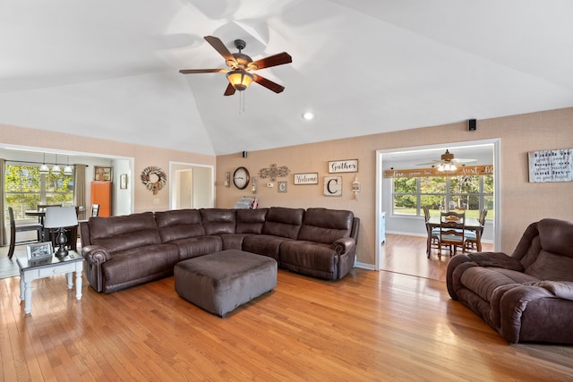 living room with ceiling fan, high vaulted ceiling, and light hardwood / wood-style flooring