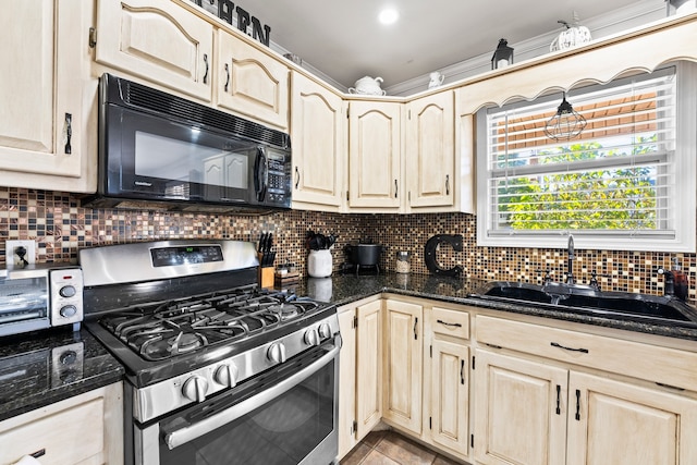 kitchen with sink, stainless steel gas range oven, and decorative backsplash